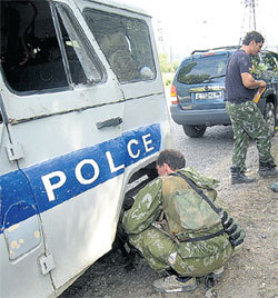 Абхазы ремонтируют машину, оставленную паникующими грузинскими полицейскими