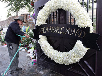 Рабочий поливает венок на воротах поместья «Neverland»